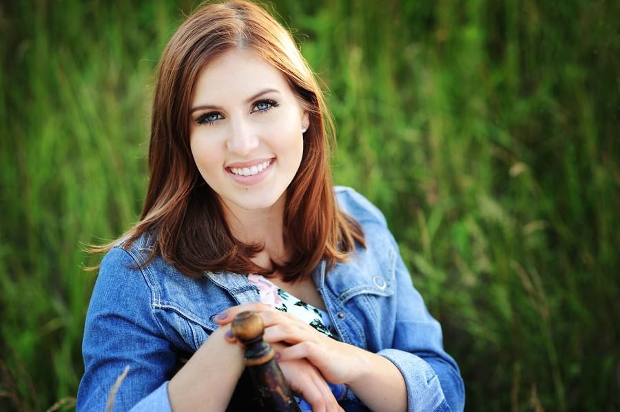 A student demonstrates the power of her smile in her senior portrait