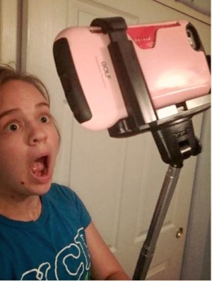 Alexa uses a selfie stick to take a selfie.