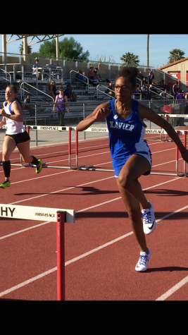 Senior track member Cydeni Carter competes in the hurdles. 