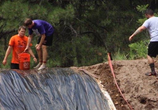 These participants prepare for the final obstacle in their mud race. 