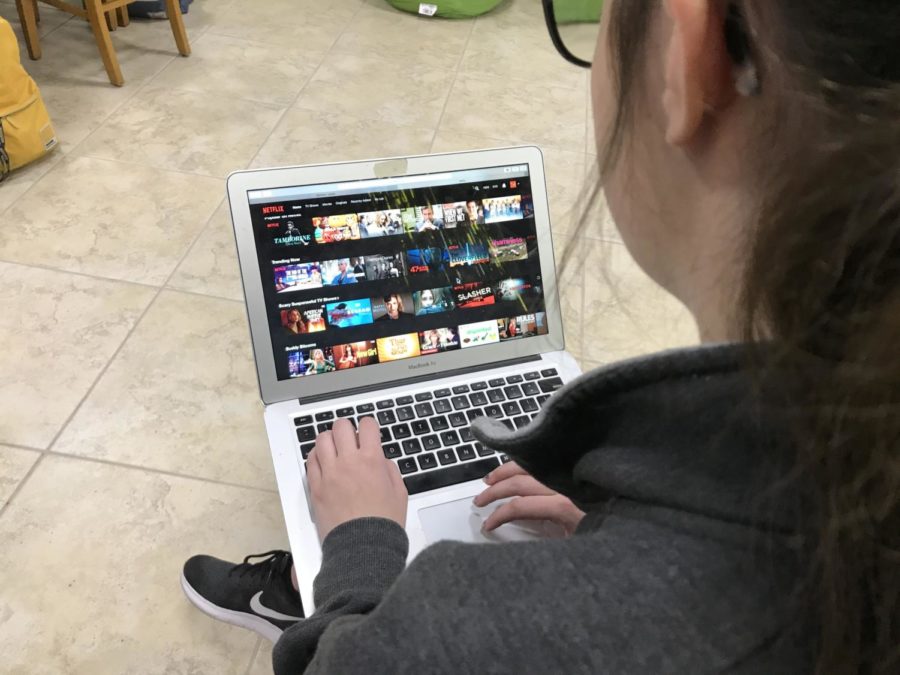 Xavier student watching Netflix while in class, a typical side effect of binge-watching syndrome