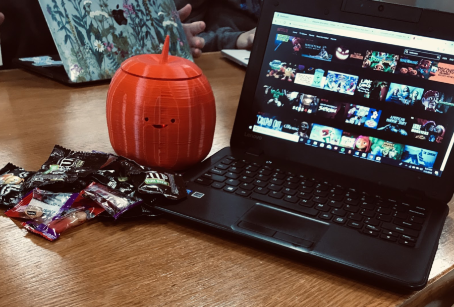 A photo of the Halloween section of Netflix along with a pile of various candies. 