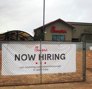 A Now Hiring sign in-front of Chik-fil-a, a common workplace for students. 
Photo Credit: Janessa Gutierrez 21