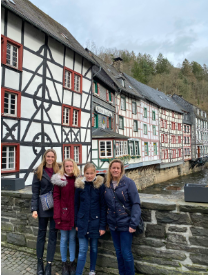 Carlie Herrmann ‘20 stands in front of beautiful architectural buildings in the Netherlands, with her German exchange family. Photo Credit: Carlie Herrmann ‘20.