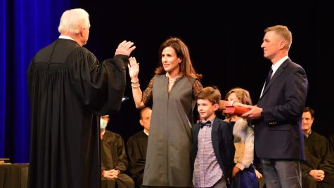 Kathryn Hackett King steps forward during the administration of oath presided over by Robert M. Brutinel, Chief Justice. She is joined by husband William F. King and children Emilia and John. Supreme Court Justices, judges, and 400 spectators gathered in Xavier’s PAC.