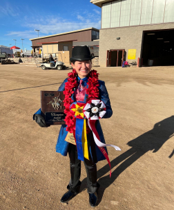 Simone Zurawski poses with her awards in front of the equidome where she was competing. Simone was Champion in the Junior division at this horse show and received a bid to Junior Nationals. 
