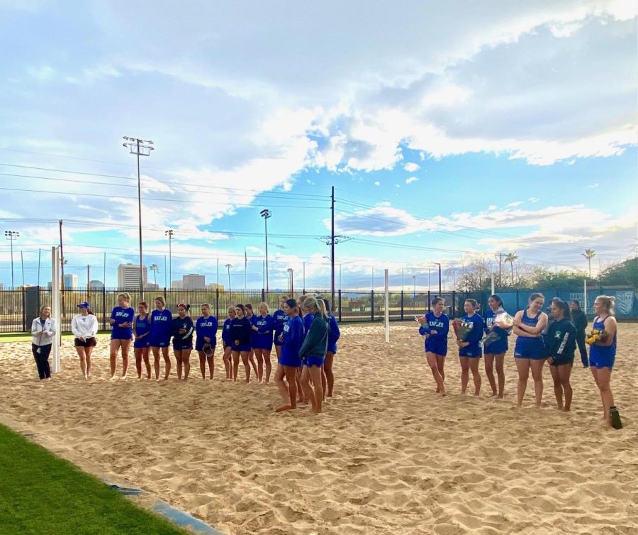 The beach volleyball team listens to the speeches given by their coaches before their game. The picture was taken on the same day as Senior Night.
