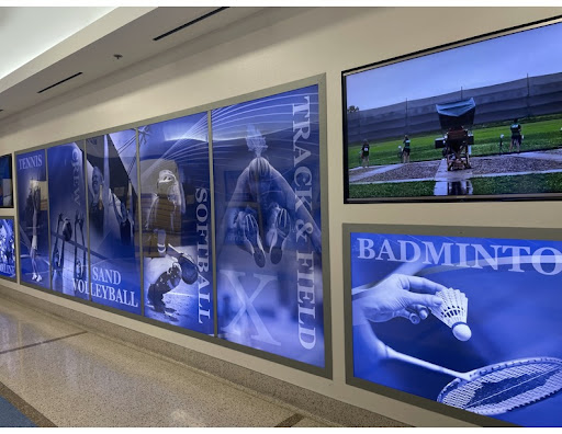 Xavier College Preparatory’s Activity Center’s hallway, which leads to the gym, is decorated with images of every sport students can participate in. Televisions feature every sports team picture, individual shots and video highlights of the sports.