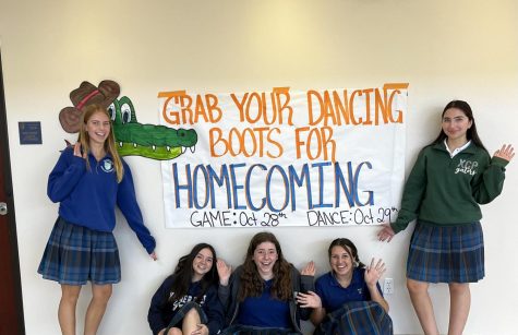 Xavier students pose in front of one of the homecoming promotion signs. These signs, created by PUB Club and the homecoming committee, are posted around campus to increase the homecoming spirit of the students.
