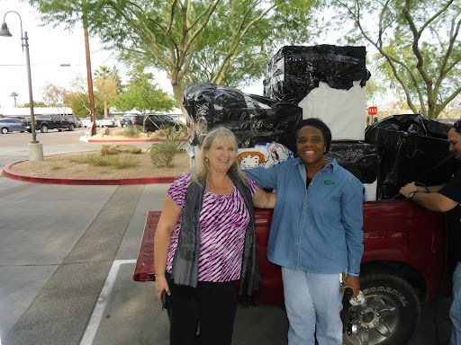 Joanne Sweeney (founder of JumpStart Ministries) and Rhonda Golden (volunteer) pose in front of boxes filled with toys. The boxes were distributed to the hundreds of children whose parents could not afford to buy them Christmas presents. 