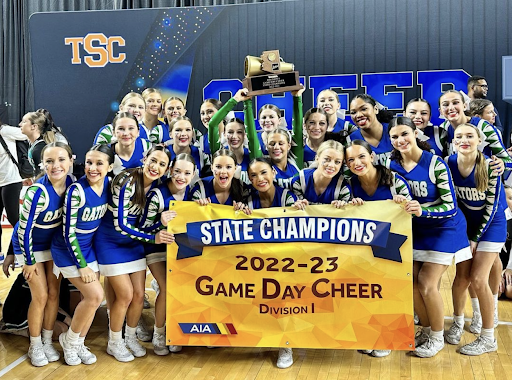 Spiritline cheer poses with their Game Day trophy and another state championship banner. The team could not have been more thrilled about their epic win at  Arizona Veterans Memorial Coliseum. (Photo courtesy of Monica Gaspar)