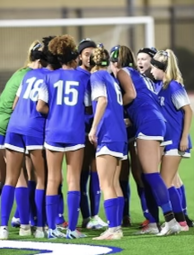 The varsity team gathers for a quick team huddle before facing its opponent. Mustering up strength, it pulled out another win, continuing its undefeated season.