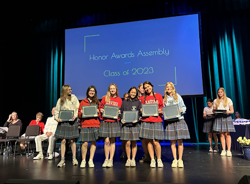 Senior National Merit Scholars stand together after being recognised at the awards assembly on Friday. Beforehand, seniors rode through the busy streets towards Xavier on bikes, a unique senior tradition. 