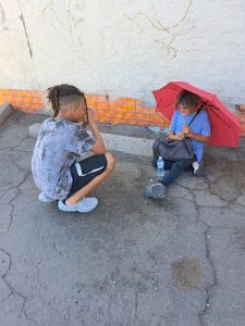 Cam Benson takes a moment of prayer after handing out a bottle of water and umbrella to help a homeless woman in need. At just 13 years old, Benson is excited to be making an impact on his local community. 
