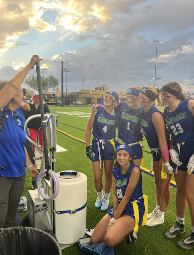 Xavier flag football athletes take a quick break using the sideline mister during their win against Mountain Ridge. Athletic trainer Laurie White strives to keep the athletes cool by spraying them. 