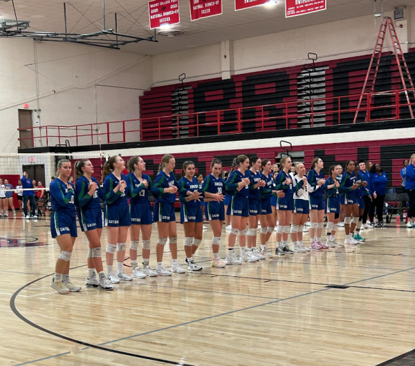 Xavier Varsity Volleyball team holds hands as they line up to say the pledge of allegiance and a pre-game prayer. They are preparing to play their next game against Mountain View where they were able to gain another win. (Photo courtesy of Savannah Landrum Taylor, XPress Staff)
