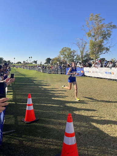 Senior Julia Russo strides through the finish line as she completes her race at the cross country state championships. She finished in 19:07, placing sixth at state. (Photo courtesy of Vivian Amoia)