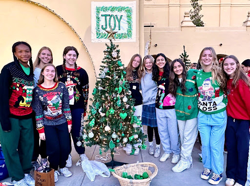 Xavier’s Junior Student Council poses next to its tree on November 30, 2023, during Xaviers annual Christmas Tree Lighting. The green tree symbolizes the junior class color, with the word Joy above. (Photo courtesy of Sister Lynn Winsor)