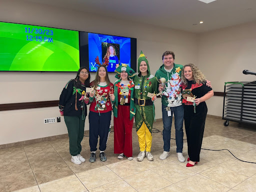 The winners of the Ugly Christmas Sweater Contest pose for a picture and celebrate their win. From left to right, Angelica Abril ‘26 Most Elaborate, Kamea Oudman ‘27 Ugliest in Show, Annika Dowdall ‘26 Most Elaborate, Teagan Bitcraft ‘25 Most Christmasy, Zach Carlson Best in Show, and Peggy Clay Faculty/Staff Runner-Up. (Photo courtesy of Vivian Amoia, XPress Staff)