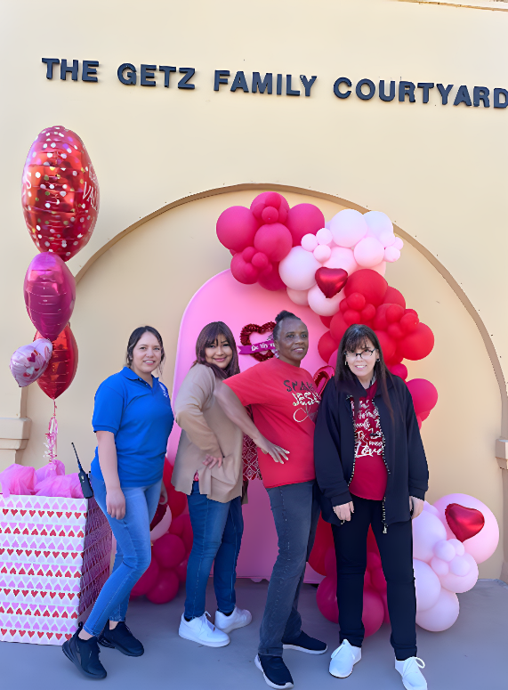 Jessica Contreras Perez, Marisela Morales, Rhonda Golden and Kim Pfaff pose in front of the Getz Family Courtyard bell tower. The staff decorated the courtyard with Valentines Day decorations.