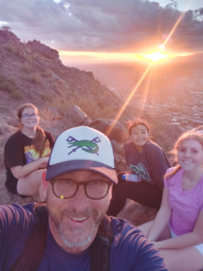 Coach Geoffrey Stricklin and three crew members take a selfie at the top of Camelback Mountain in Phoenix, Arizona. Stricklin loves exploring different mountains in the Phoenix area and enjoys bringing his team with him. (Photo courtesy of Geoffrey Stricklin)