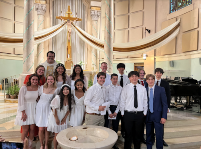 Converts from last year’s sacrament Mass at St. Francis gather with Father Harold Escarcega. Both Brophy and Xavier students are shown. (Brianne Pennington)