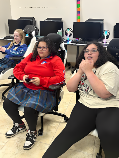 Esports players Ana Bramlett ‘25 and Mareya Ramirez ‘24 play in a competition against Valley Christian High School as Angel Moreno ‘24, on the right, watches. The girls are playing Smash Bros at the competition. (Photo courtesy of Zachary Carlson)