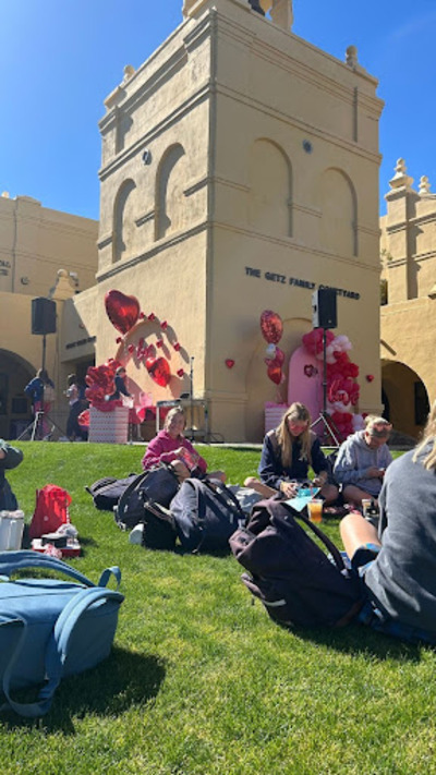 Seniors sit by the bell tower on Wednesday, February 13, as they appreciate the Valentines Day decorations and music courtesy of Rhonda Golden. They enjoy the nice weather with their senior treats, including goodie bags and Streets of New York pizza.