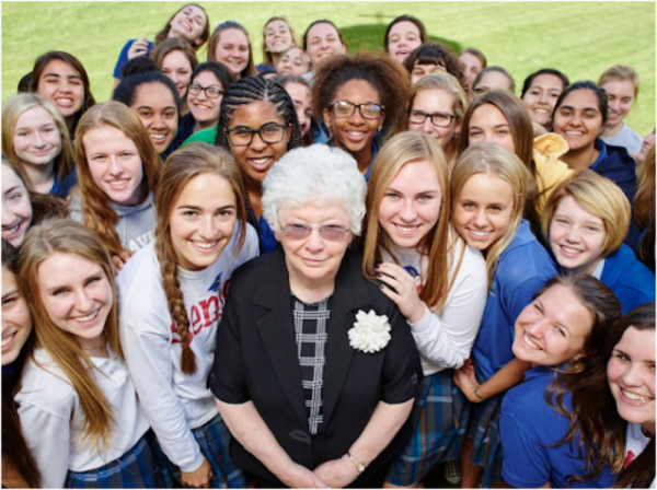 Sister Joan Fitzgerald has served Xavier for over 60 years. She is looking up with students. (Photo courtesy of Xavier College Preparatory Instagram)