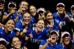 The softball Gators pose holding up number one shortly after winning the state championship game. With smiles and glitter on their faces, they cheer to celebrate their victory.