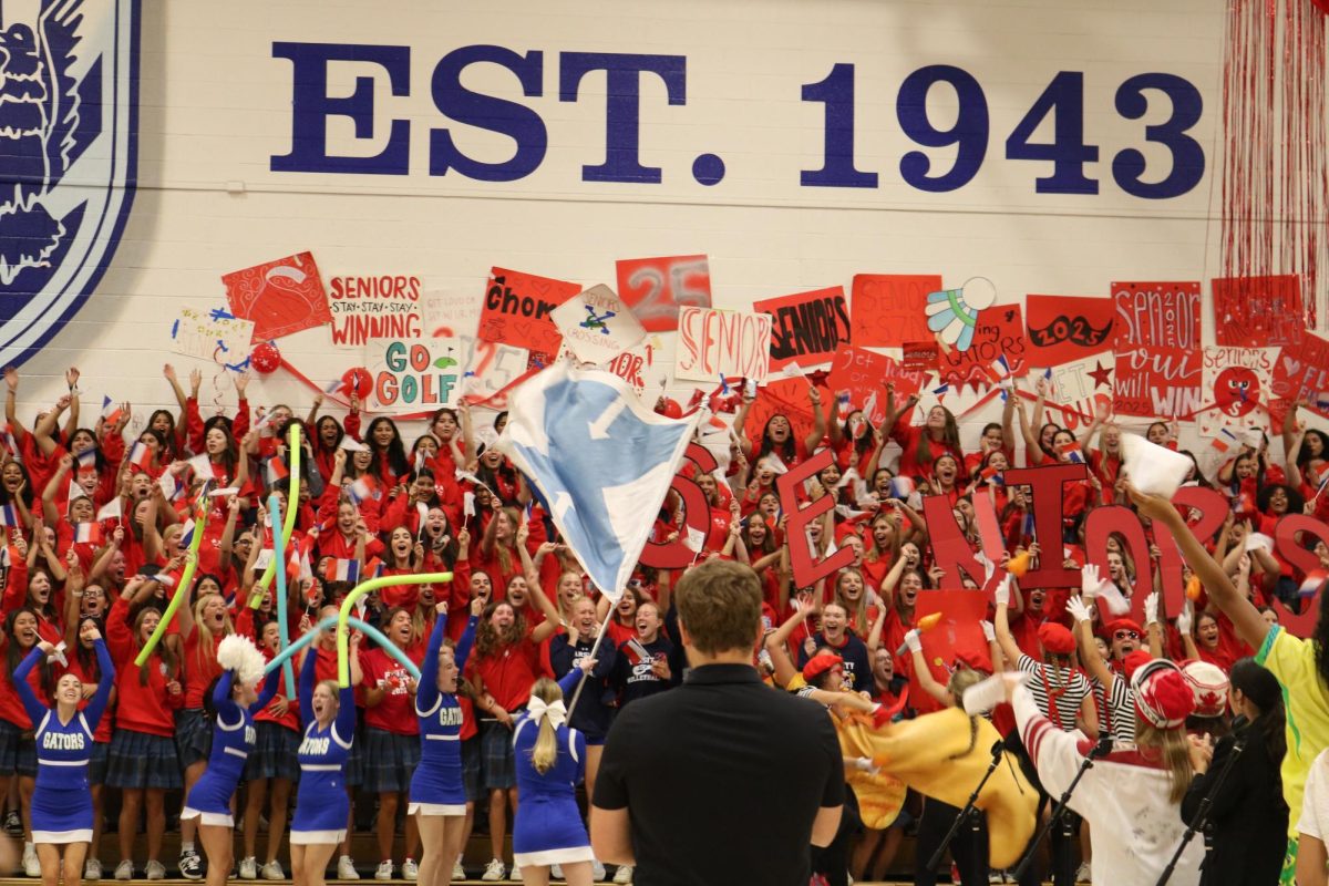 The senior class celebrates as they win the Fall Sports Rally. The gym is decorated with signs and flags representing the Paris Olympics.