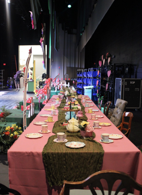 The main table, a part of the “Alice in Wonderland” set, has props and chairs. This table will be used in a variety of scenes, with most of the cast.