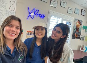 XPress lead editors, Charley Fisher (right) and Vivian Amoia (left), pose for a selfie with Danna Galindo Morales (middle). The three girls stand in the newspaper classroom, FH210.