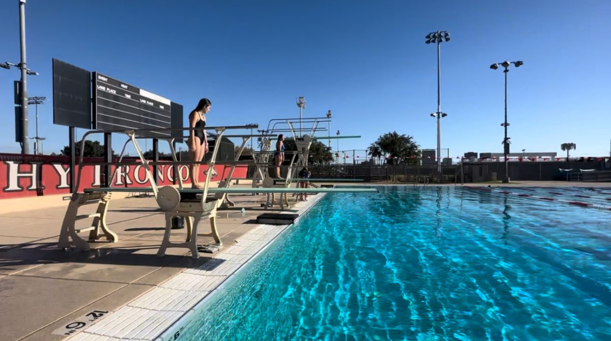 Former divers prepare to do synchronized dive on the three meter board at the Brophy pool. This year the swim and dive team is ranked third in the state.