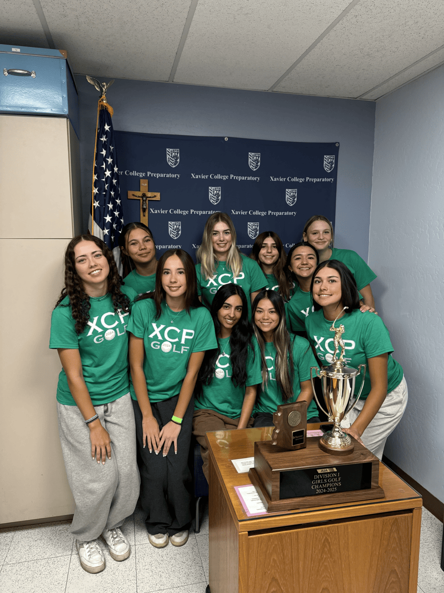 The golf team poses with its first place trophy as teammates prepare to announce their win on morning announcements. These Gators took first at the Division I state championships this Tuesday at Aguila Golf Course.