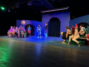 The cast of “The SpongeBob Musical” practices a scene from the show as it closes out its first week of tech-week on Friday, November 8. The stage is illuminated by the loud costumes and brightly colored set and prop pieces. 