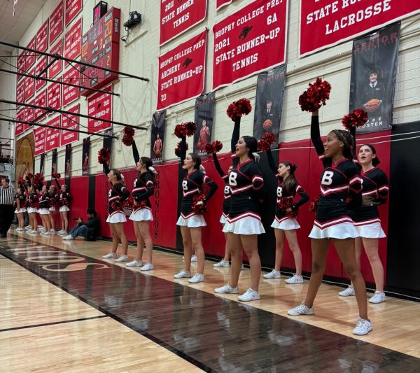 Gatorline holds their poms in the air at the Brophy senior night basketball game at home versus Corona del Sol. They are chanting the cheer, “Go red, go white, Broncos let's fight.” 