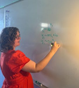 Claire Yablong explains common mathematical equations in her classroom. During her free period, Yablong explains these equations to an XPress member with curiosity about them.