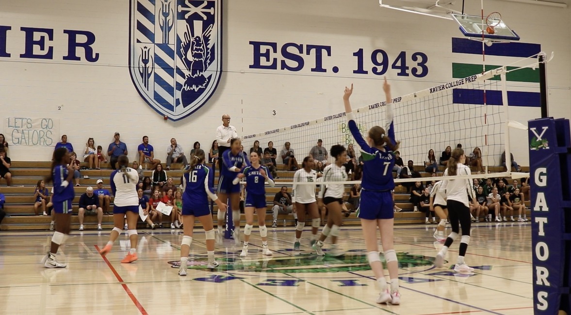 On September 10, the Xavier varsity volleyball team defeated Basha High School, 3-0, and the players celebrate as Tessa Larkin '27 hits a set-winning spike. New athletic director Tui Selvaratnam now leads this and all of Xavier's successful sports' teams into the future.