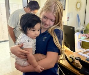 Senior Lucy Churchill holds Kaiti-Lynn Beazley’s baby boy, Forrest. Beazley sometimes brings Forrest to her third period Kairos class, and the girls love it when this happens. 