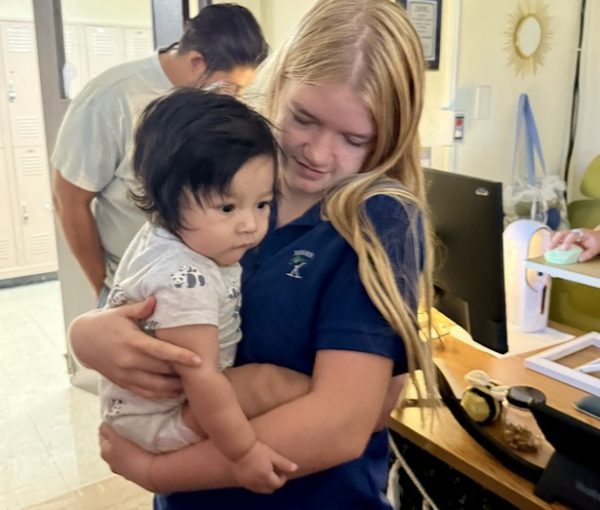 Senior Lucy Churchill holds Kaiti-Lynn Beazley’s baby boy, Forrest. Beazley sometimes brings Forrest to her third period Kairos class, and the girls love it when this happens.