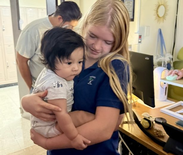 Senior Lucy Churchill holds Kaiti-Lynn Beazley’s baby boy, Forrest. Beazley sometimes brings Forrest to her third period Kairos class, and the girls love it when this happens. 