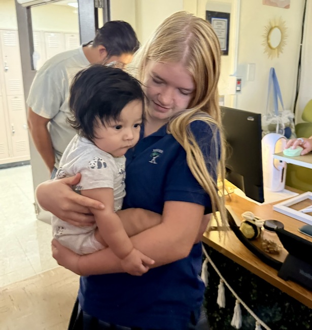 Senior Lucy Churchill holds Kaiti-Lynn Beazley’s baby boy, Forrest. Beazley sometimes brings Forrest to her third period Kairos class, and the girls love it when this happens. 