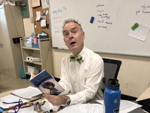 English teacher Dr. Clay Zuba poses for a photo in his classroom. He is one of many teachers at Xavier with an impressive background in a variety of subjects.