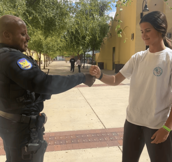 Officer Rey Benson and Emery O’Connor '29 practice a handshake outside of Founders Hall. The interaction reflects the officers’ efforts to build familiarity and connection with the campus community.
