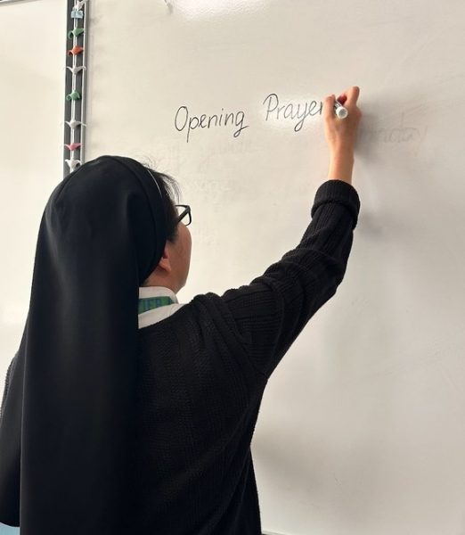 Sister Theresa Trang, sophomore theology teacher at Xavier, prepares her class for a lecture. Trang always begins class with a Bible quote and prayer to reflect on the day.