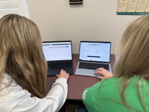 Two students pose in front of opposing national newspapers, The Wall Street Journal and The New York Times. Even these sources of news often present bias and make it difficult for young adults to decipher fact and to form opinions.