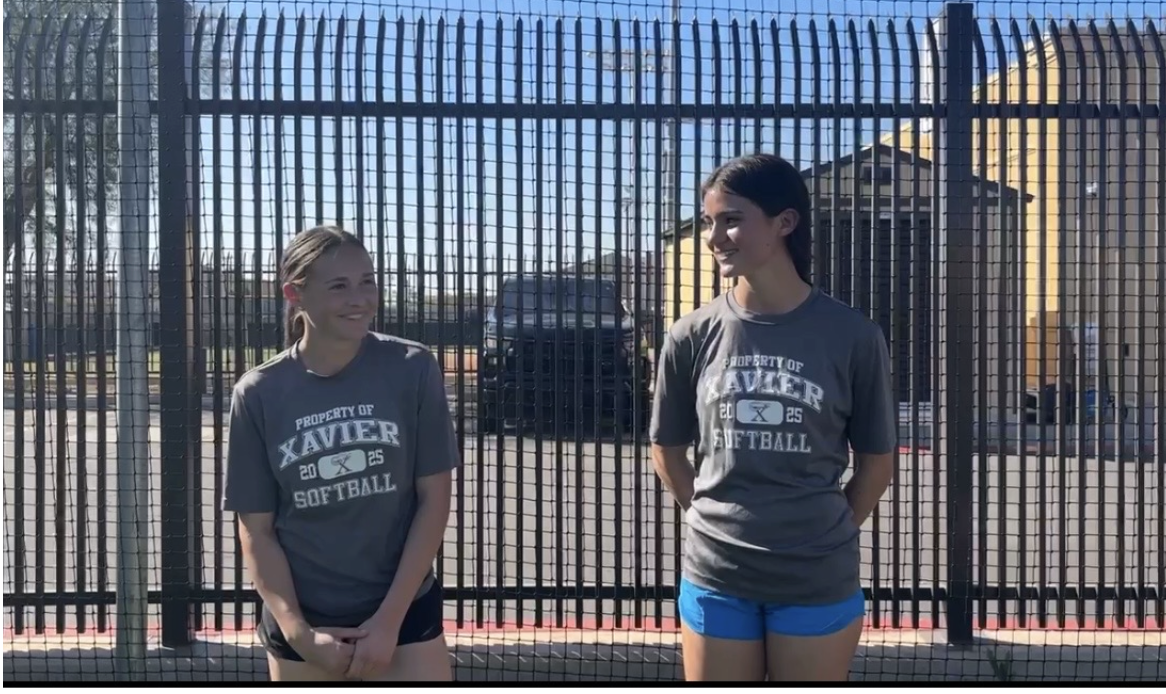 Sydney Root and Angie Falls stand for an interview on Petznick Field. They talk about their favorite parts of being on Xavier’s varsity softball team.