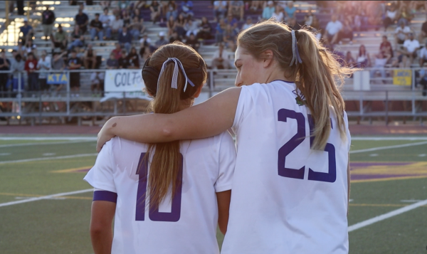 Number 25 Sophia Knox '27 and Number 10 Olivia Yu '26 share a hug as they walk onto the field prior to the state championship game. The Gators have won for the past 5 years.
