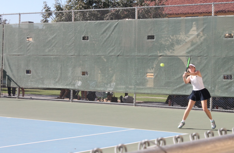 Leighton Champagne ‘28 launches into a two-handed backhand swing during an afternoon match. Champagne is undefeated this season with a record of 8 solo matches in a row.